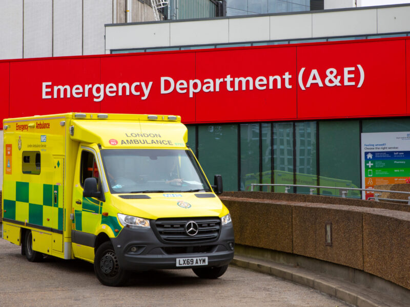 An ambulance is parked outside the emergency department at a hospital.
